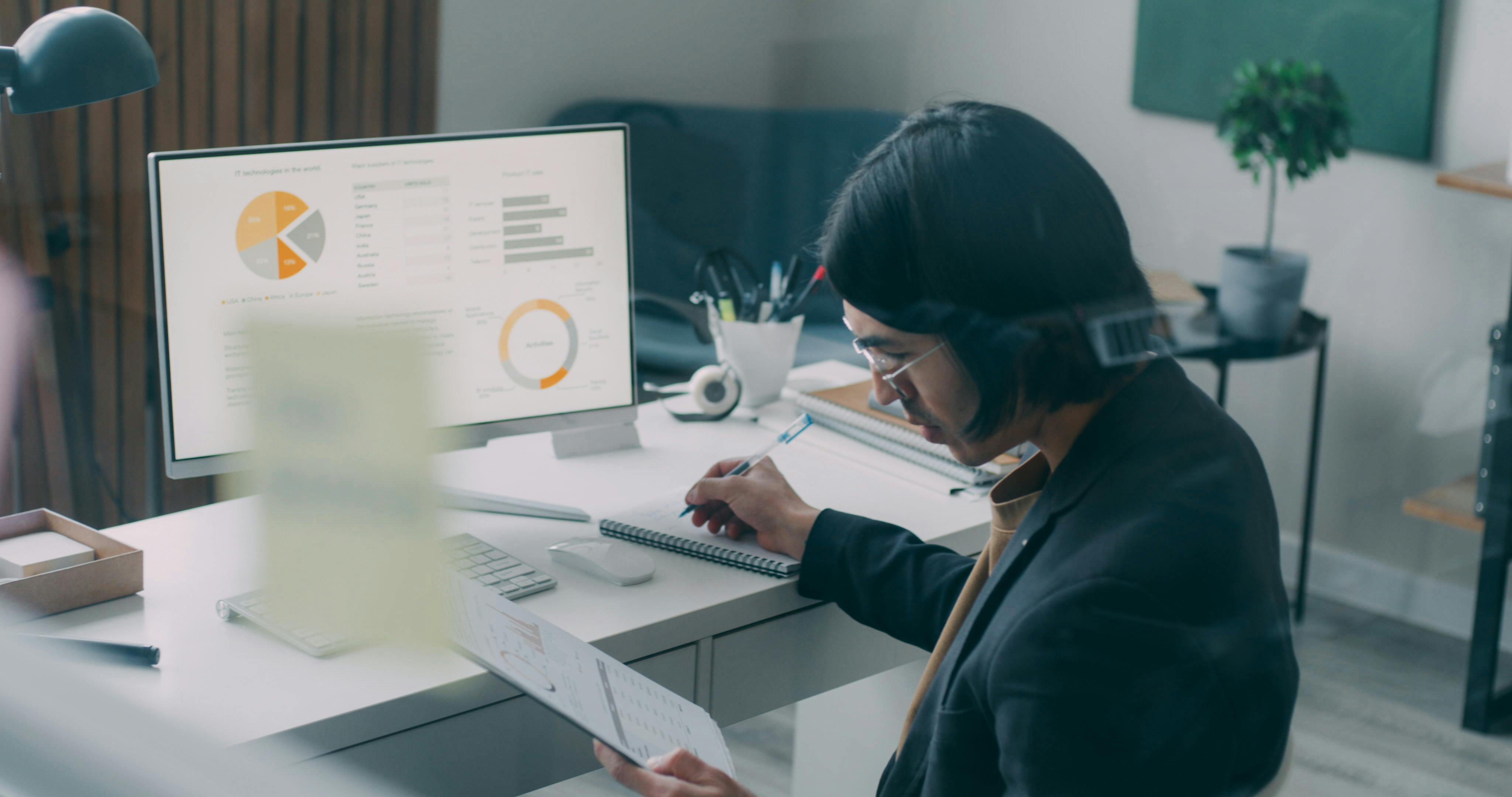 Business person reviewing analytics and charts at a modern office desk.