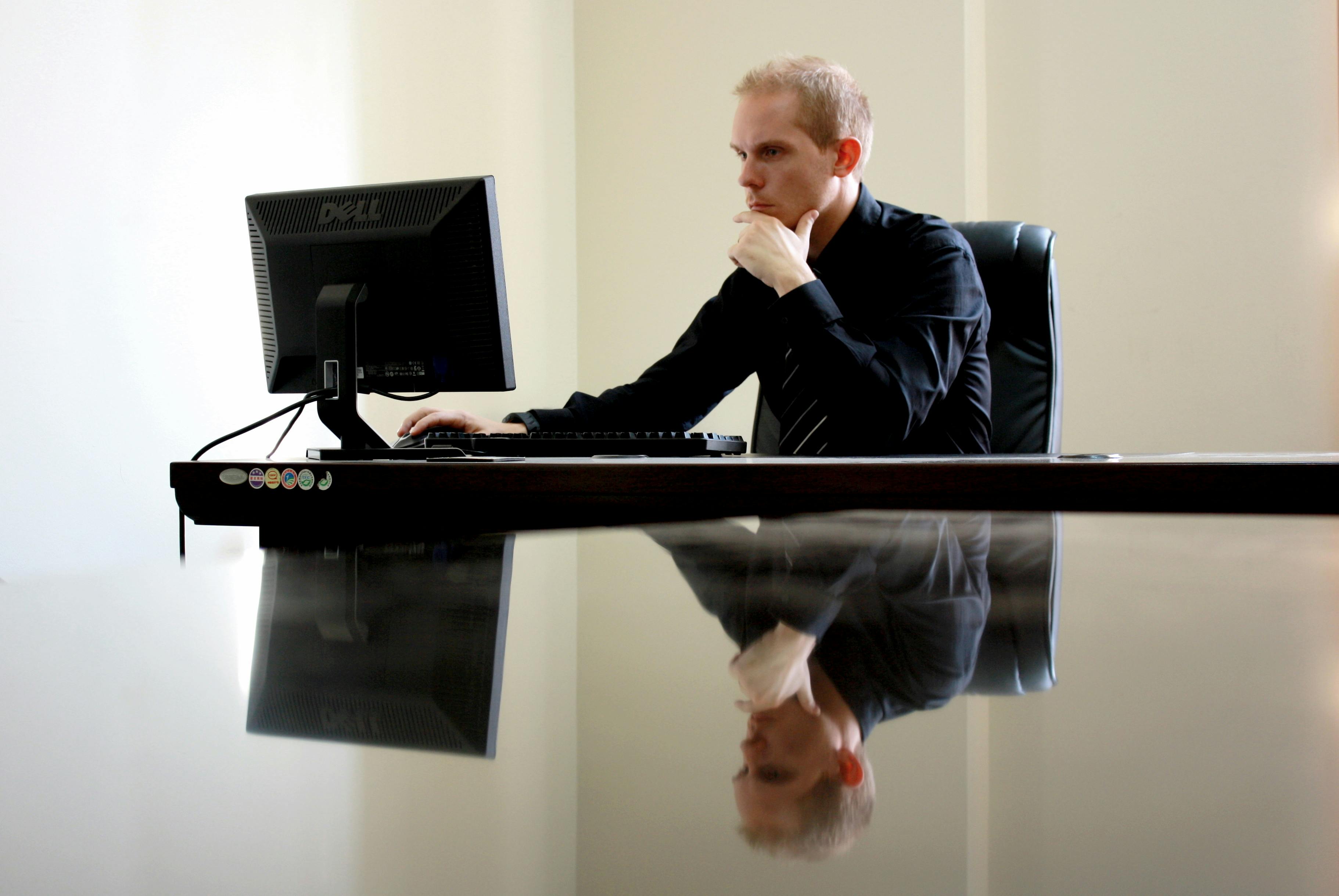 A businessman in deep thought at his desk, reflecting on work tasks.